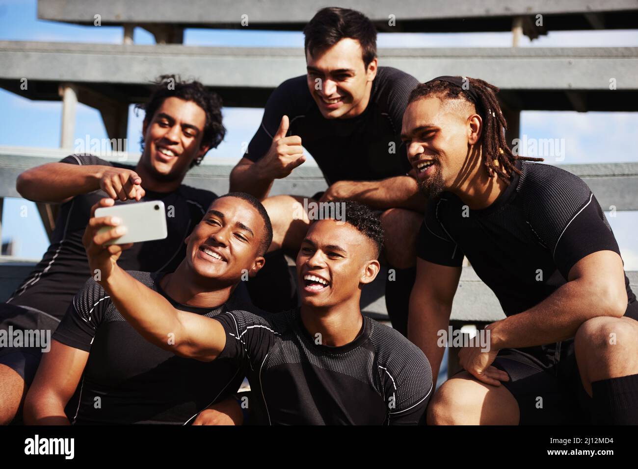 Il relativo non tempo di metà fino a che non prendete un selfie. Scatto di un giovane che prende un selfie con i suoi compagni di squadra in una partita di rugby. Foto Stock
