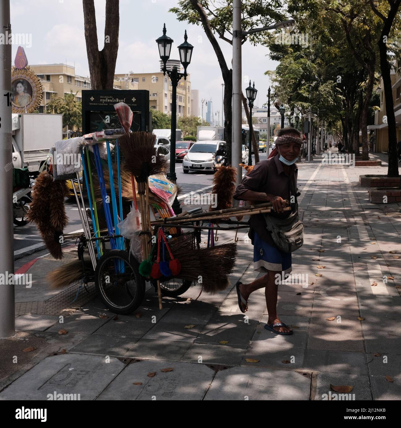 Uomo con Push Cart il Monumento alla democrazia Khaosan Road Area Ratchadamnoen Avenue intersezione di Dino Road Bangkok Thailandia Foto Stock