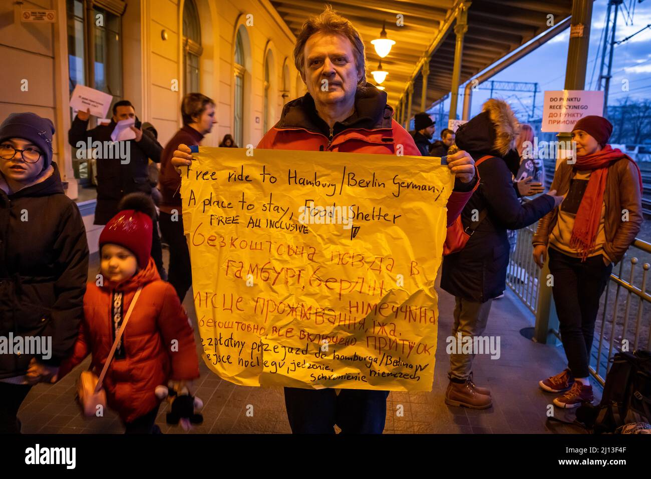 Volontariato offre gite e alloggio con il suo cartello in cartone presso la stazione ferroviaria di Przemysl, in Polonia, non lontano dal confine polacco-ucraino. Qui i rifugiati sono dotati di cibo e vestiti caldi. Da qui vengono inoltrati ad alloggi su larga scala o collettivi. Foto Stock