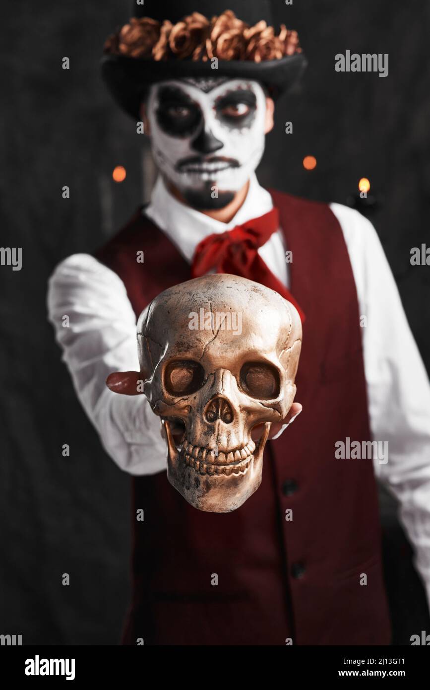 Giorno dei morti. Ritratto corto di un bel giovane uomo vestito con il suo  costume di Halloween in stile messicano che tiene fuori un teschio Foto  stock - Alamy