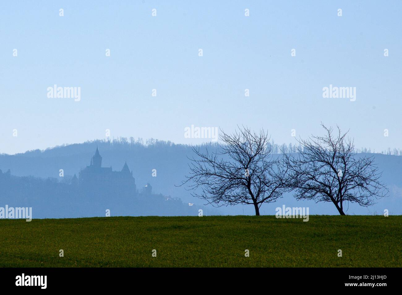 Wernigerode, Germania. 22nd Mar 2022. Il castello di Wernigerode si sbiadisce e svanisce in condizioni di tempo torbido di fronte alle pendici dei Monti Harz. Rimane soleggiato fino alla fine della settimana. Allo stesso tempo fa freddo con le notti stellate. Credit: Klaus-Dietmar Gabbert/dpa-Zentralbild/ZB/dpa/Alamy Live News Foto Stock