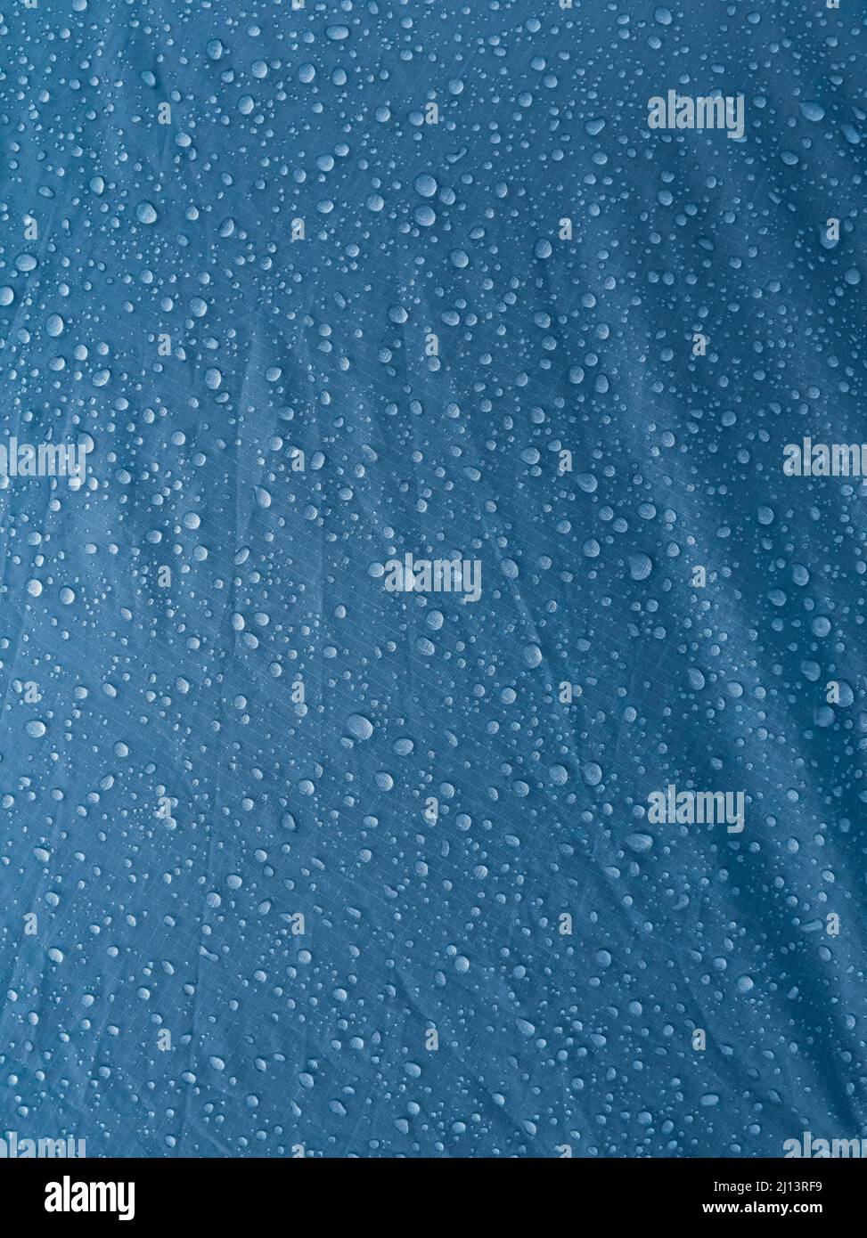 Gocce d'acqua sul tessuto impermeabile della membrana. Rugiada del mattino sulla tenda. Foto Stock