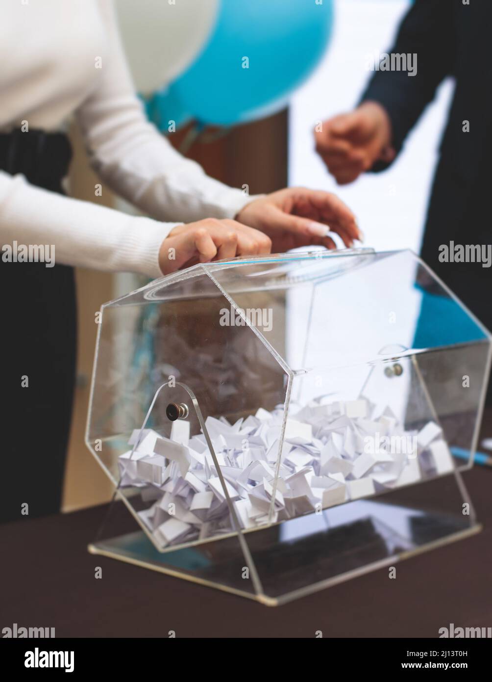Processo di estrazione dei premi, estrazione di un numero vincente di lotteria macchina, tamburo di lotteria con bingo palle e vincita dei biglietti in occasione dell'evento con l'ospite e Foto Stock