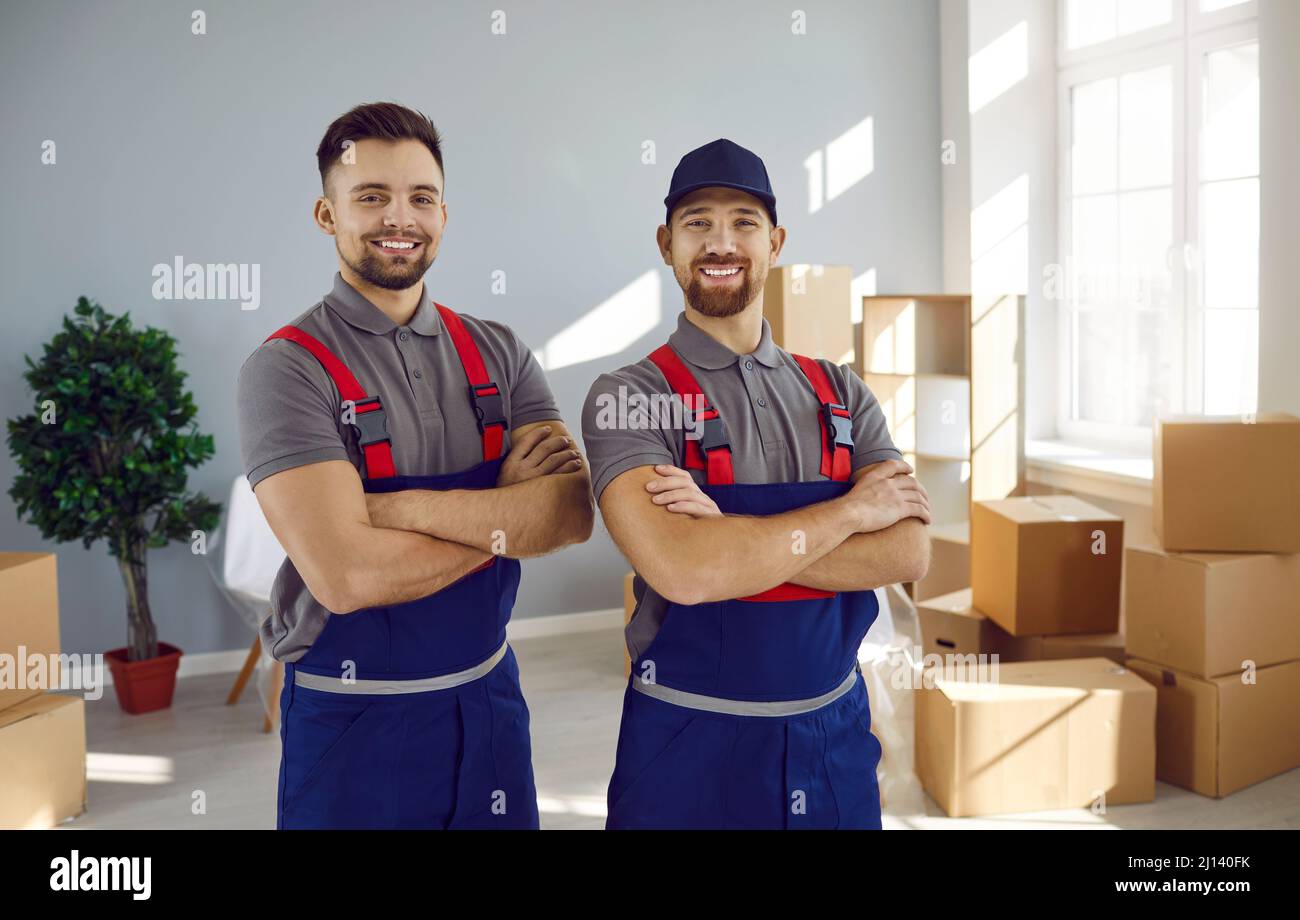 Due giovani dipendenti allegri di servizio in movimento in tute stanno sorridendo di fronte alla macchina fotografica. Foto Stock