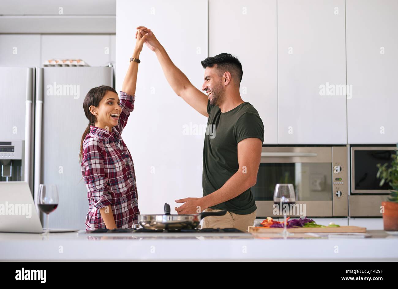 Facciamo cucinare insieme e noi saremo bene. Scatto corto di una giovane coppia attraente che cucinano insieme nella cucina a casa. Foto Stock