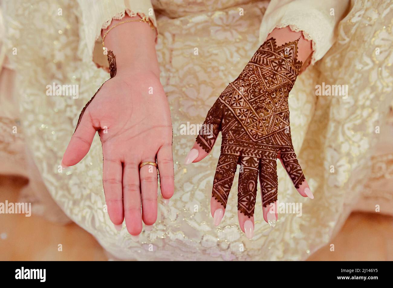 Artista che applica il tatuaggio henné sulle mani delle donne. Il Mehndi è un'arte decorativa tradizionale marocchina. Primo piano, vista dall'alto Foto Stock