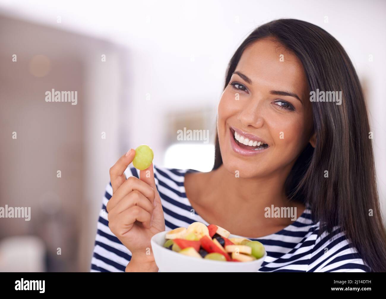 Tanta bontà in qualcosa di così piccolo. Ritratto di una bella giovane donna che tiene la sua insalata di frutta. Foto Stock