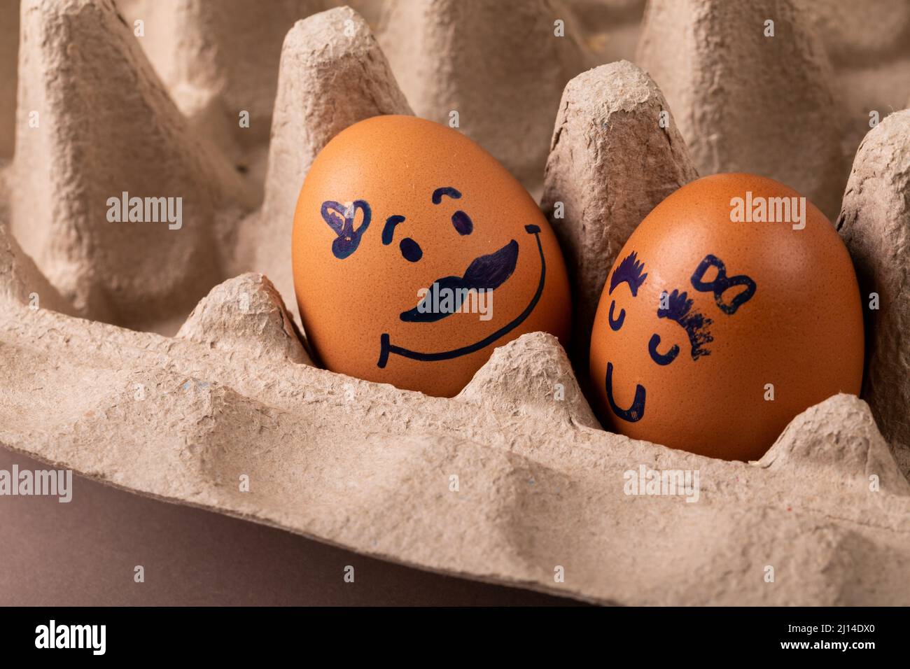 Primo piano del disegno creativo sulle uova marroni in cartone Foto Stock