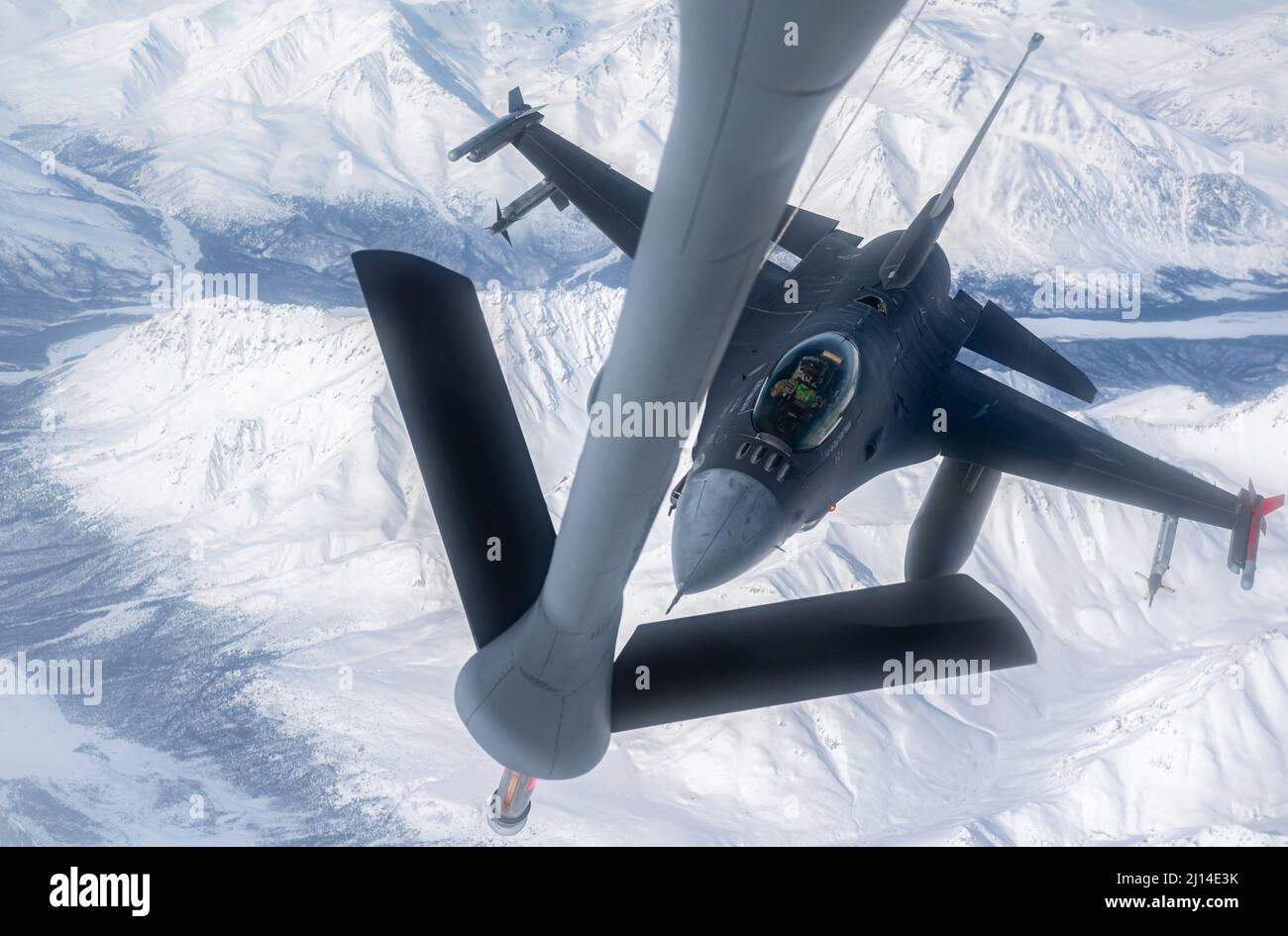 Alaska centrale, Stati Uniti. 16 marzo 2022. Un aereo dell'aeronautica degli Stati Uniti F-16 Fighting Falcon jet, assegnato a 180th Fighter Wing, si avvicina ad un KC-135R Stratotanker che rifornisce l'aereo durante l'operazione Arctic Edge, 16 marzo 2022 sopra l'Alaska. L'esercizio del comando del Nord fa parte delle recenti mosse militari volte a scoraggiare il coinvolgimento della Russia in Ucraina. Credito: SSgt. Trevor T. McBride/U.S.A. Air Force/Alamy Live News Foto Stock