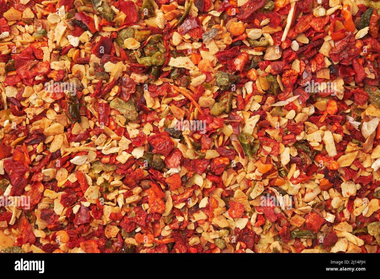 Mix di spezie per la cottura dei piatti. Fiocchi di peperoncino rosso, paprika, aglio, cipolla. Closeup condimento essiccato. Vista dall'alto. Foto Stock