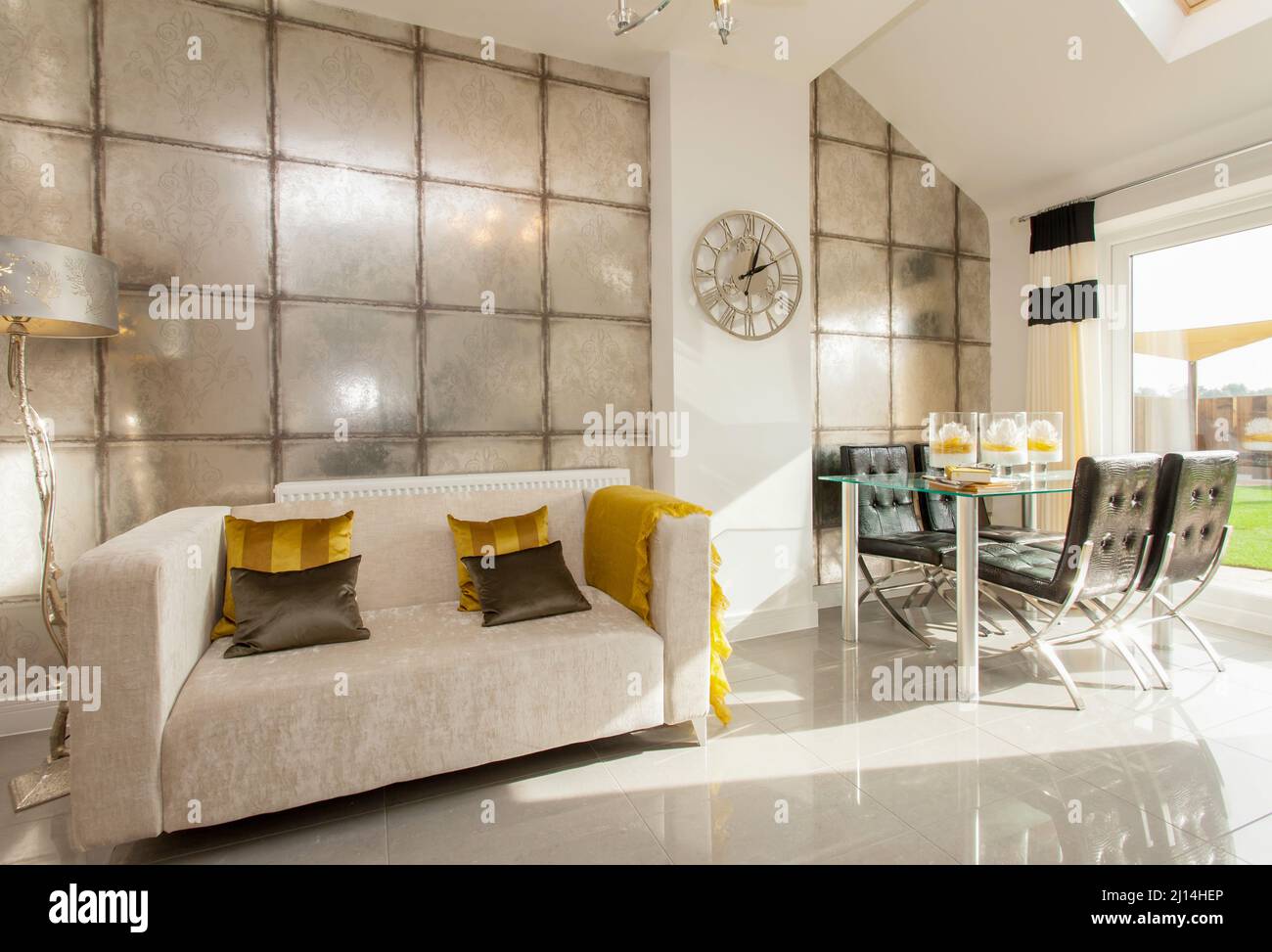 Soggiorno pranzo in casa moderna, divano letto, tavolo da pranzo e sedie, pavimento piastrellato. Foto Stock