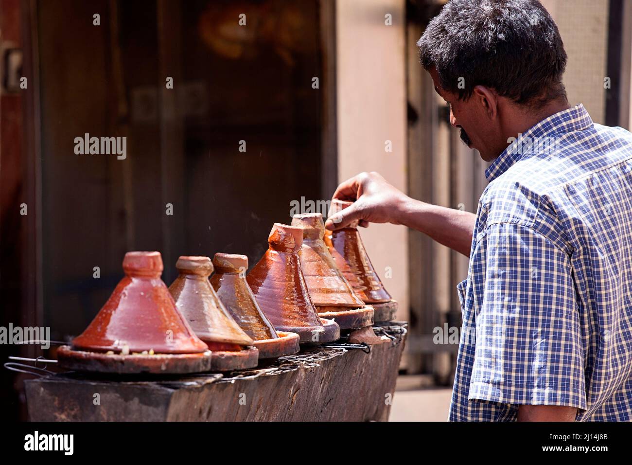 Gli uomini locali marocchini preparano il pranzo in una tradizionale tagine marocchina, Marocco Foto Stock