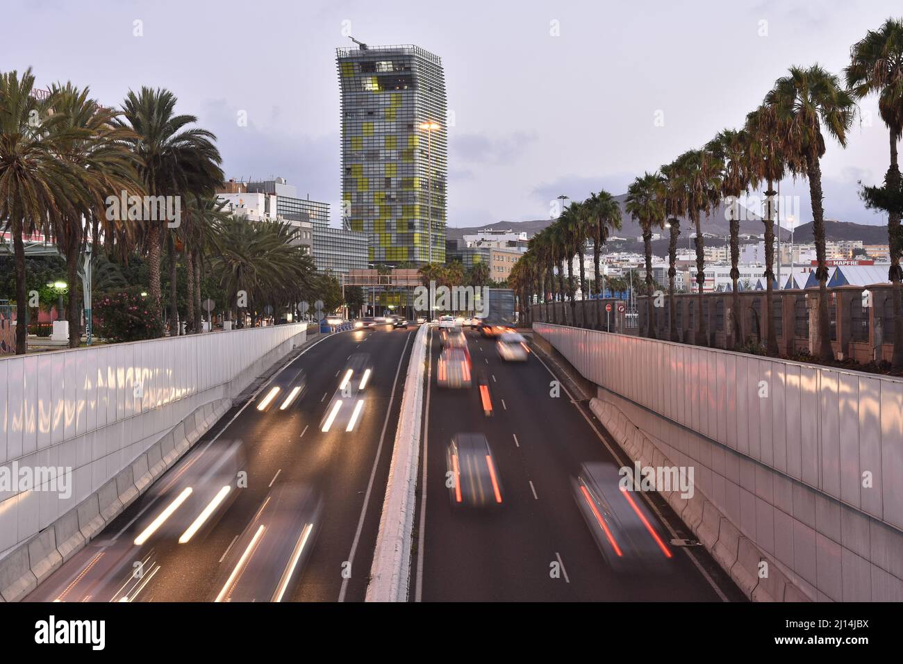 Auto in movimento sul vialetto all'alba e la moderna torre Woermann pietra miliare architettura nella città di Las Palmas di Gran Canaria Spagna. Foto Stock