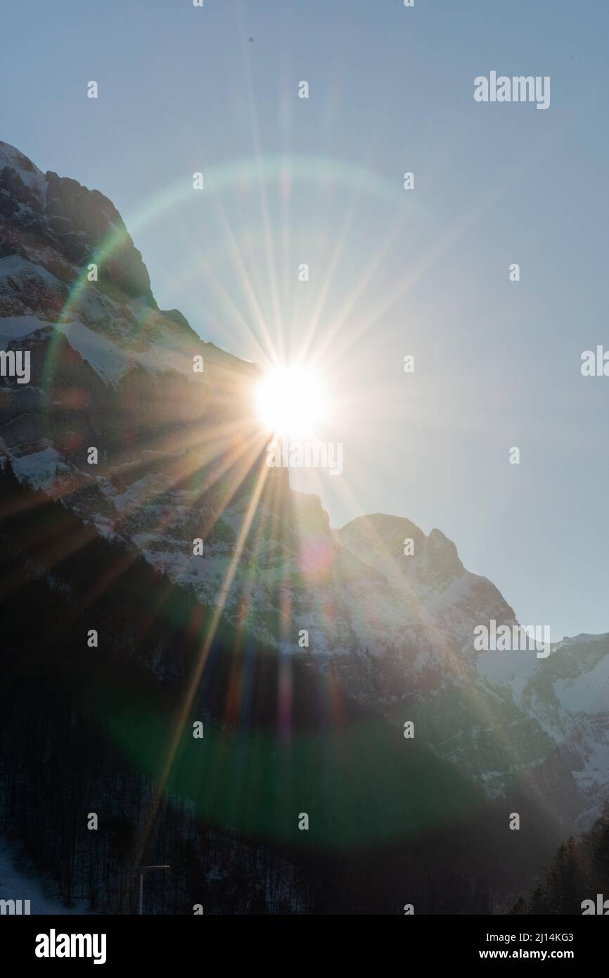 Wasserauen, Appenzell, Svizzera, 26 gennaio 2022 il sole sta scomparendo dietro le maestose alpi Foto Stock