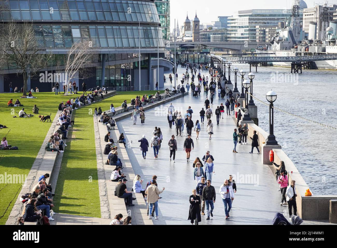 Le persone che si godono una giornata di sole al Queen's Walk Promenade a Londra, Inghilterra, Regno Unito, Regno Unito Foto Stock
