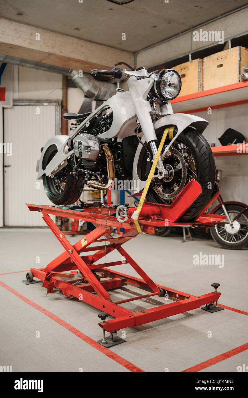 Fissaggio motocicletta personalizzata in piedi in officina. Strumenti e attrezzature. Hobby e lavori unici Foto Stock