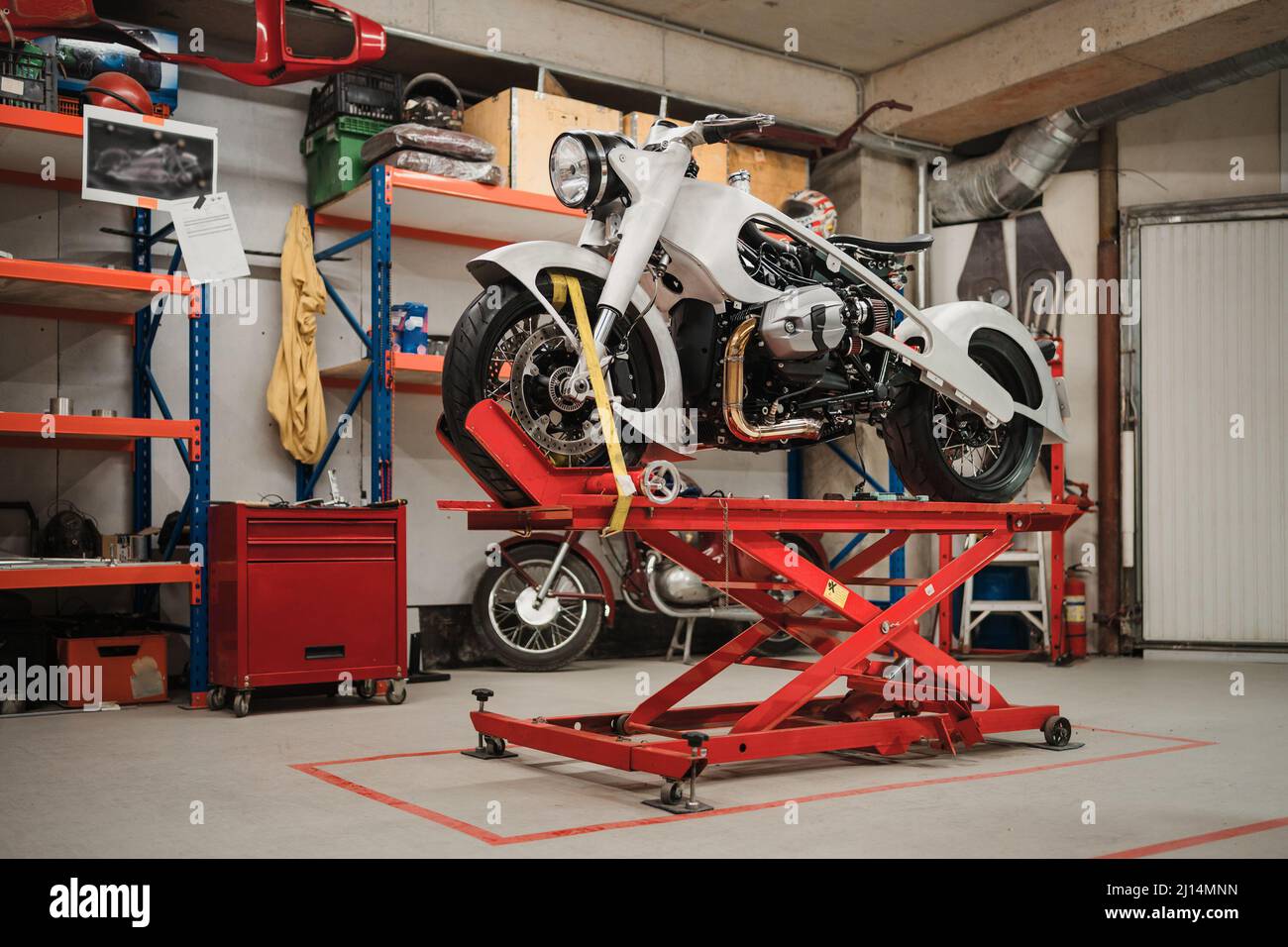 Fissaggio motocicletta personalizzata in piedi in officina. Strumenti e attrezzature. Hobby e lavori unici Foto Stock