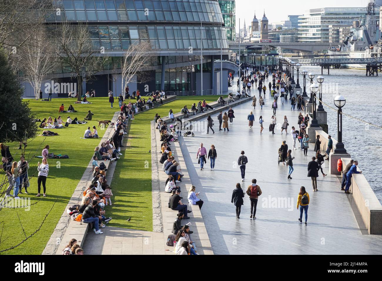 Le persone che si godono una giornata di sole al Queen's Walk Promenade a Londra, Inghilterra, Regno Unito, Regno Unito Foto Stock