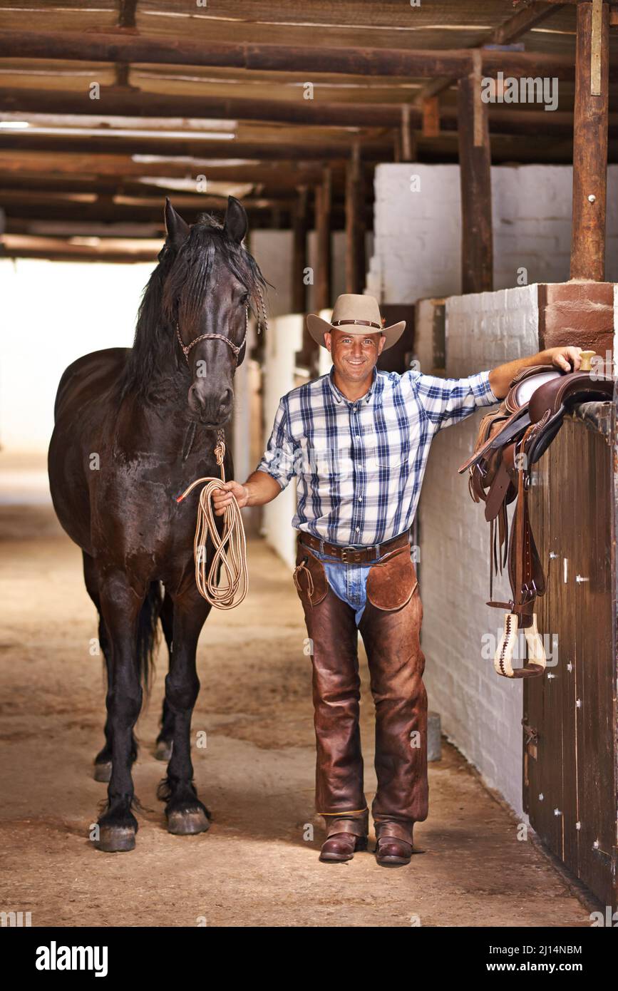 È una vita cowboy. Shot di un cowboy in una fattoria. Foto Stock