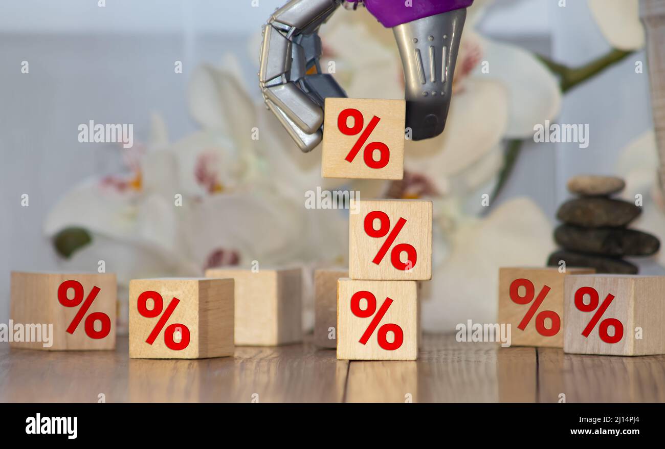Tasso d'interesse finanziario e ipotecario concetto di tassi. Mano che mette il blocco di cubo di legno che aumenta sulla parte superiore con il simbolo di percentuale dell'icona verso l'alto direzione Foto Stock