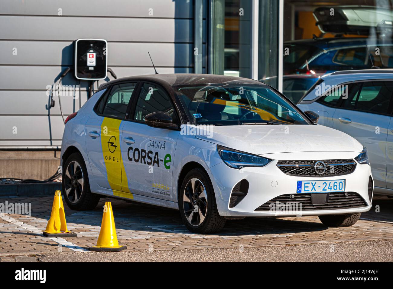 Riga, Lettonia, 18 marzo 2022: La nuova Opel corsa-e completamente elettrica presso la stazione di ricarica del centro concessionari Foto Stock