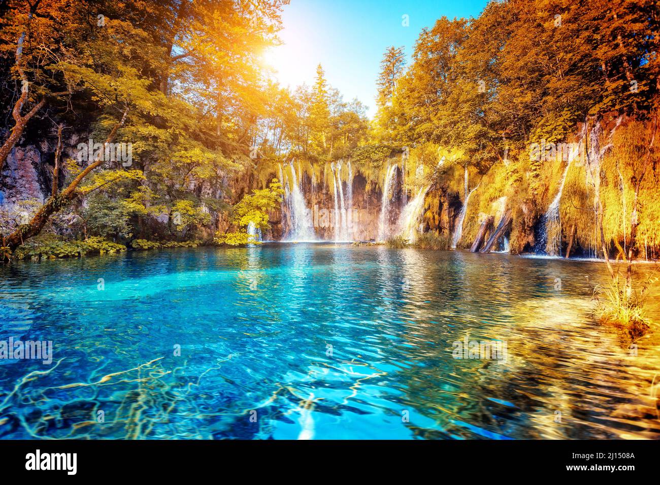 Vista maestosa sulle acque turchesi e sulle travi soleggiate. Ubicazione Famosa Località Plitvice Lakes Parco Nazionale, Croazia, Europa. Scena drammatica e vivida. Bea Foto Stock