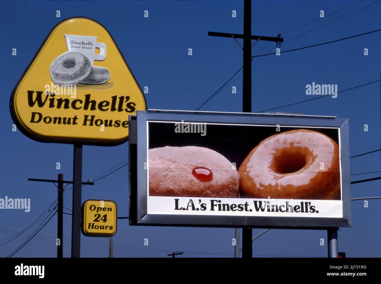 Piccolo poster pubblicitario all'aperto per le ciambelle di Winchel vicino a un cartello di Winchell's Donut House a Los Angeles, CA Foto Stock