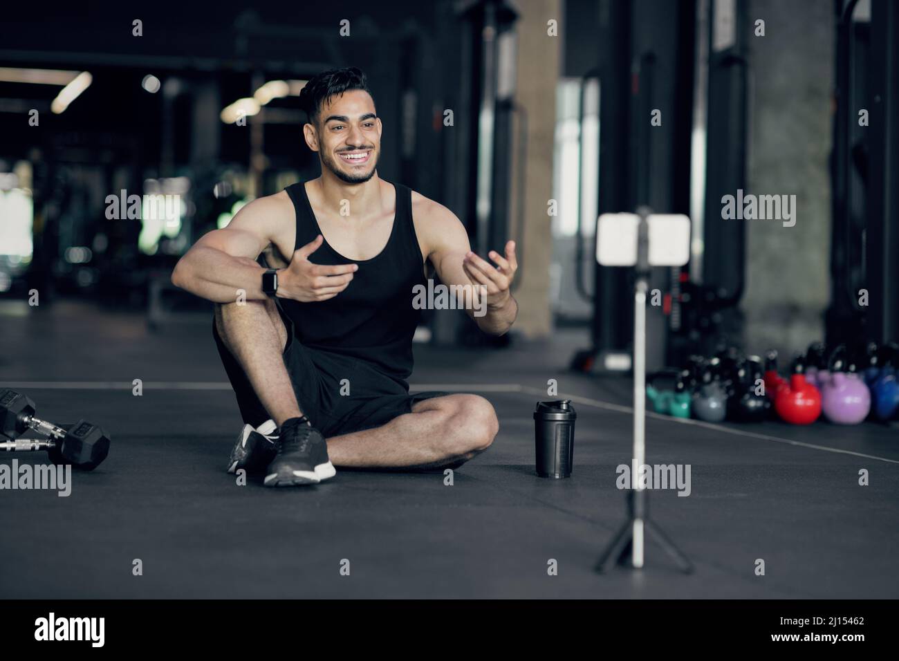 Bel blogger arabo maschio Fitness registrazione video a smartphone Camera in palestra Foto Stock