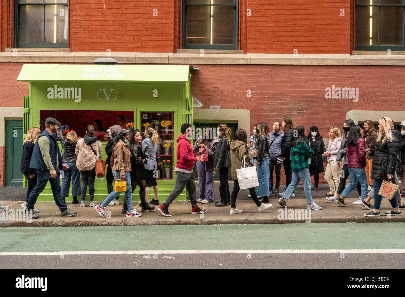 Il fashion conscio celebra l'insaponabile clima caldo, aspettando ore in fila per ricevere un bouquet di fiori all'attivazione del marchio Valentino, presentando domenica la collezione Rendez-Vous a Soho a New York. Marzo 20, 2022. Oltre ad essere data la possibilità di acquistare la merce del designer, i partecipanti hanno sperimentato fiori gratuiti, un carrello da caffè e altro ancora. (© Richard B. Levine) Foto Stock
