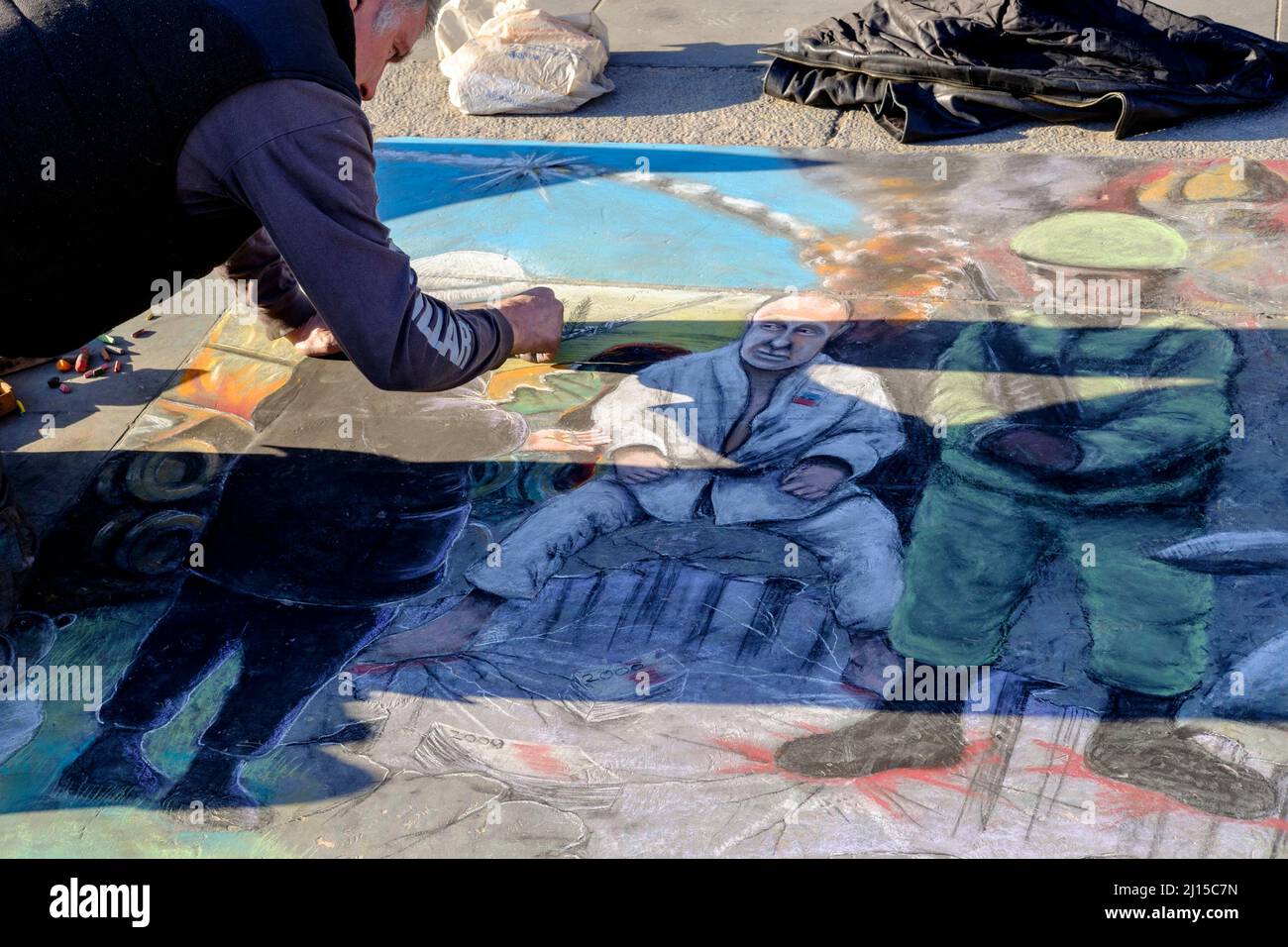 Un artista marciapiede completa opere d'arte anti-guerra raffiguranti il presidente russo Vladimir Putin. Londra, Regno Unito. Foto Stock