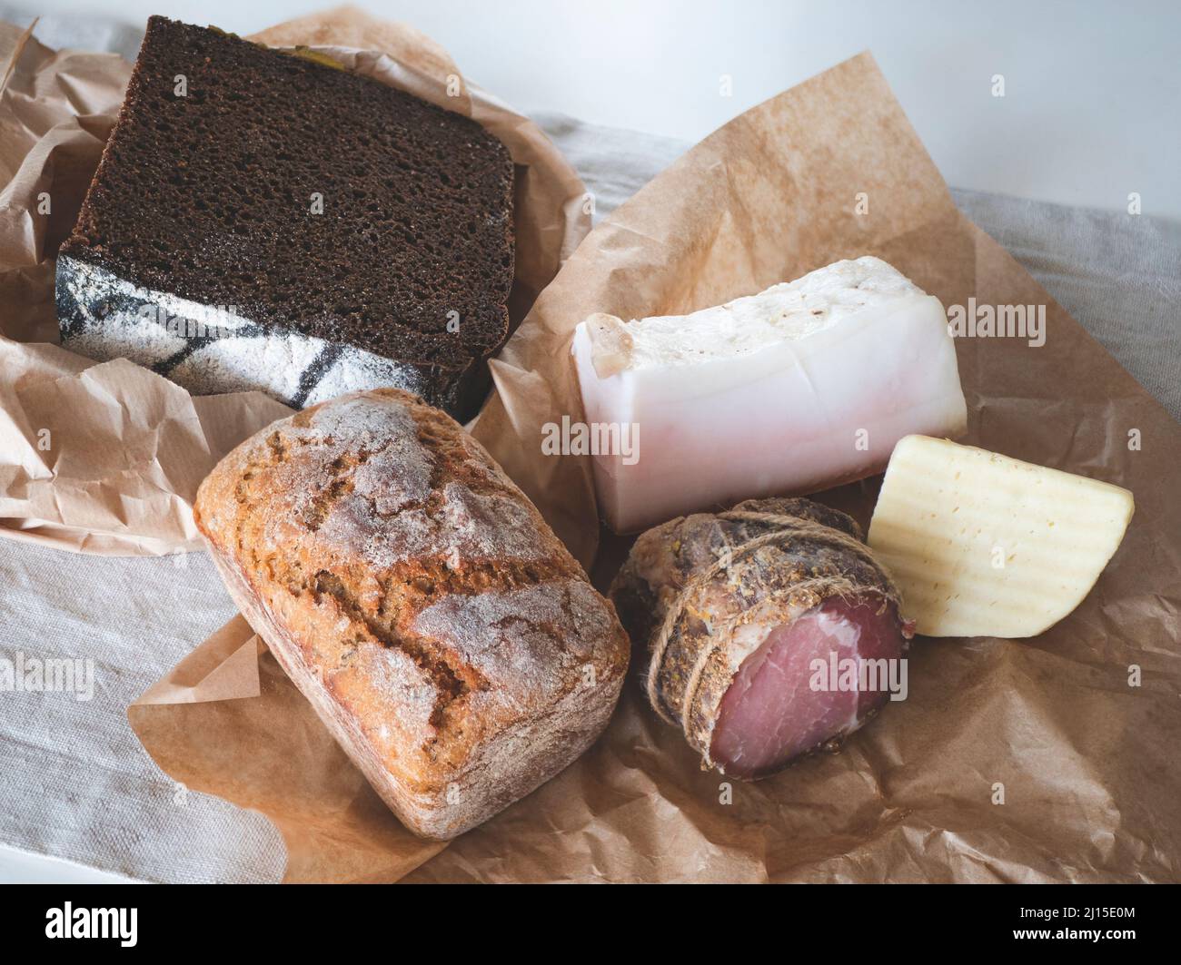 Pani di segale e di grano sourpaste pane, formaggio e carne sul tavolo. Piccolo spuntino. Concetto di prodotti agricoli freschi, cibo naturale locale Foto Stock