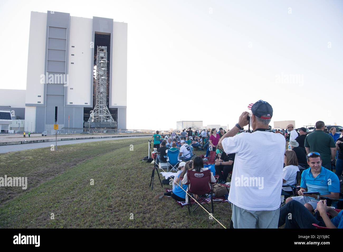 Gli ospiti invitati e i dipendenti della NASA guardano come il razzo Space Launch System (SLS) della NASA con la navicella spaziale Orion a bordo è uscito da High Bay 3 del Vehicle Assembly Building per la prima volta, giovedì 17 marzo 2022, presso il Kennedy Space Center della NASA in Florida. Prima del test di volo Artemis i della NASA, il razzo SLS completamente accatastato e integrato e la navicella spaziale Orion saranno sottoposti a una prova di vestito bagnato al Launch Complex 39B per verificare i sistemi e mettere in pratica le procedure di conto alla rovescia per il primo lancio. Photo Credit: (NASA/Aubrey Gemignani) Foto Stock