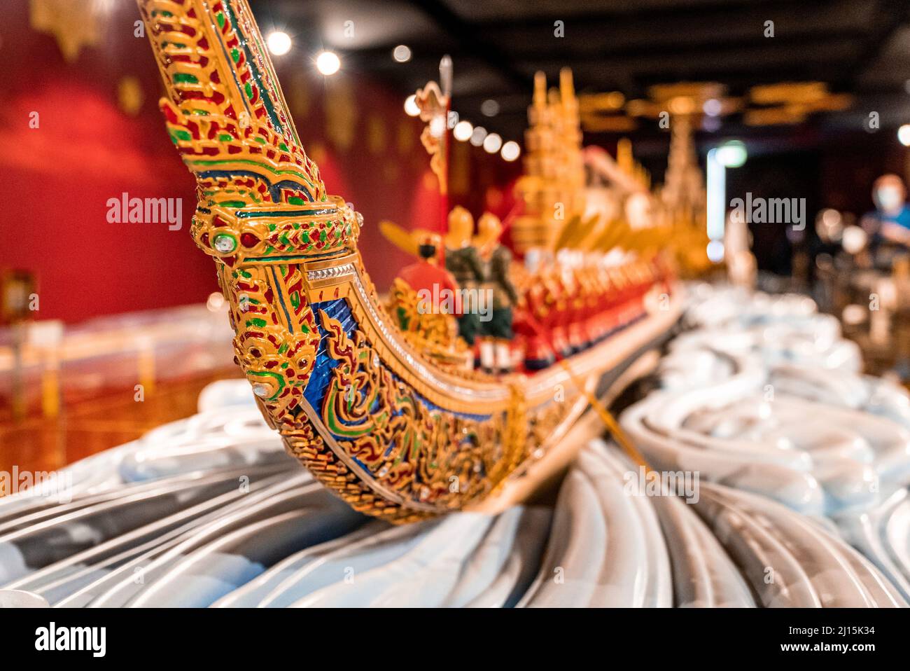Colorata barca in miniatura con disegno intagliato in legno sul tavolo Foto Stock