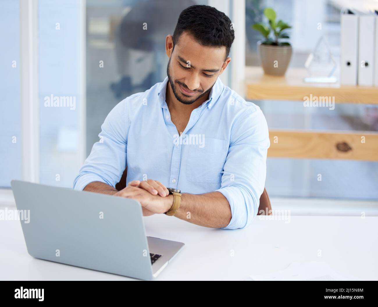 Il relativo tempo per un certo commercio. Colpo di un giovane uomo d'affari che controlla il tempo al lavoro. Foto Stock
