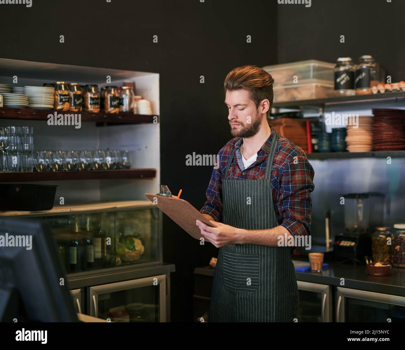 Fare il punto. Scatto corto di un proprietario giovane del caffè che fa il magazzino prende. Foto Stock