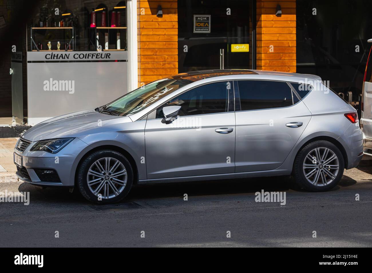 Side; Turchia – Marzo 01 2022: White Seat Leon è parcheggiata in strada in una calda giornata estiva sullo sfondo di un negozio Foto Stock