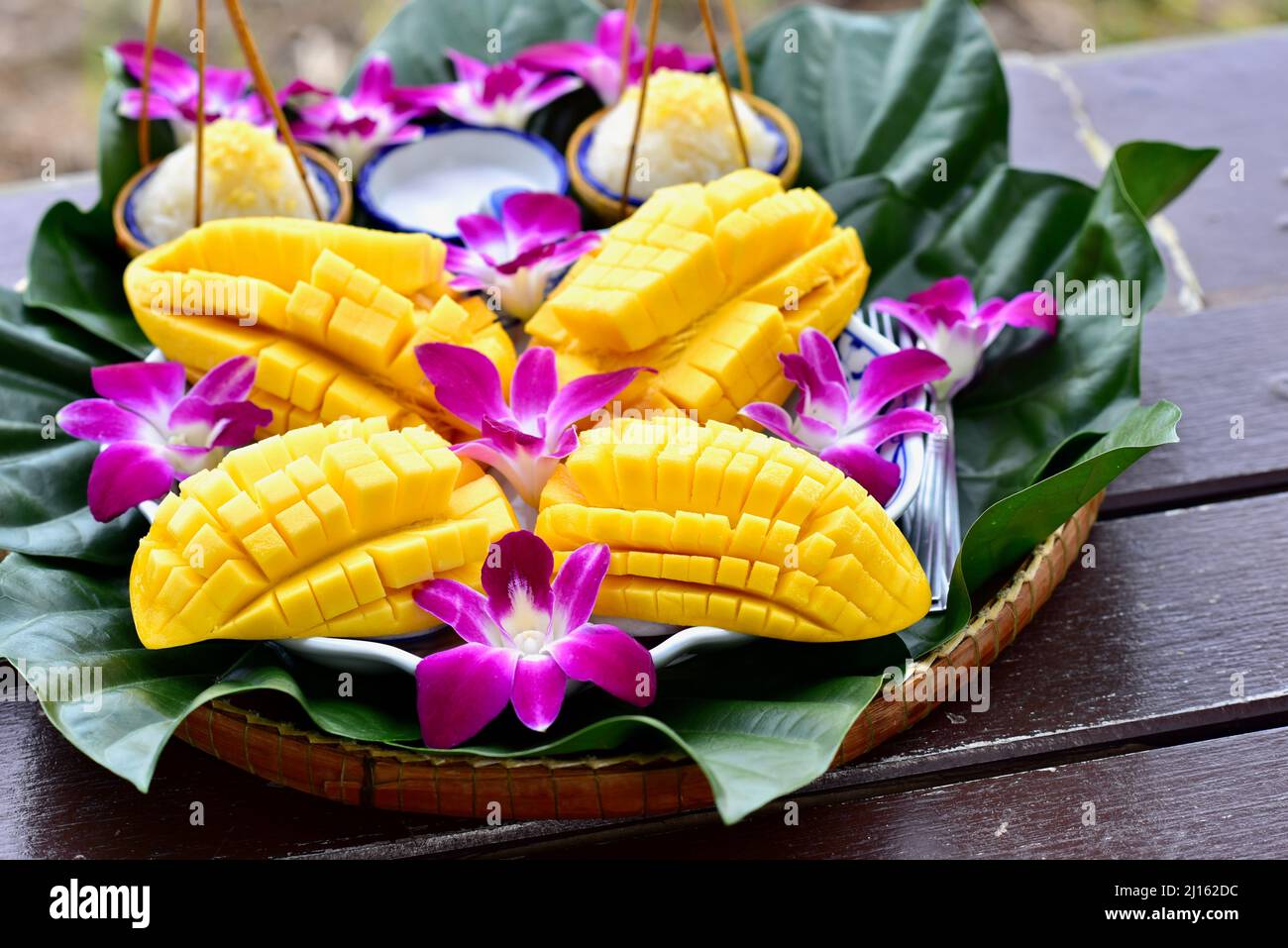 Riso Sticky Mango in stile tailandese con fiori di orchidea Foto Stock