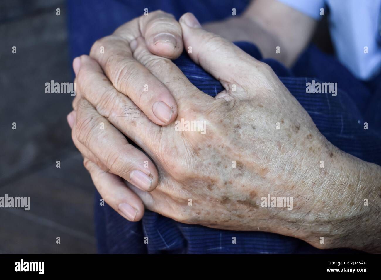 Mani aggrappate di vecchio Myanmar asiatico. Concetto di artrite reumatoide, osteoartrite o dolore articolare. Foto Stock