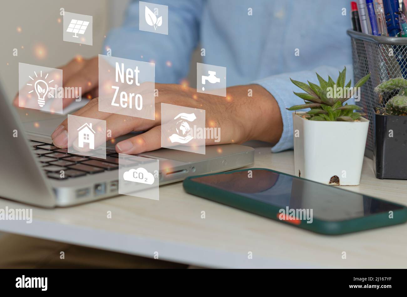 Man mano che usa il laptop per lavorare con la tecnologia e il business concept.NET ZERO icone e simboli salvare il mondo ecologico e ridurre l'inquinamento schermo virtuale. Foto Stock