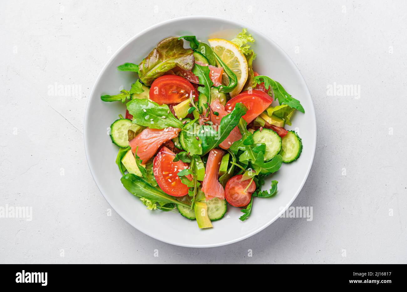 Insalata con salmone, avocado, pomodori, erbe fresche e semi di lino di sesamo. Ricco di vitamine e alimenti omega-3. Foto Stock