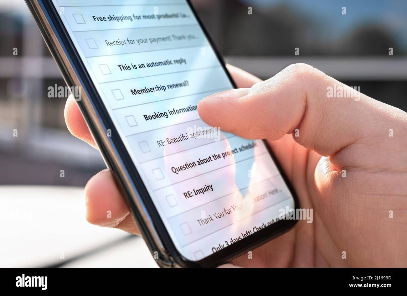 Posta in arrivo al telefono all'aperto. Elenco di nuovi messaggi non letti o posta indesiderata. Newsletter di marketing. Uomo che guarda il cellulare digitale pubblica account. Foto Stock
