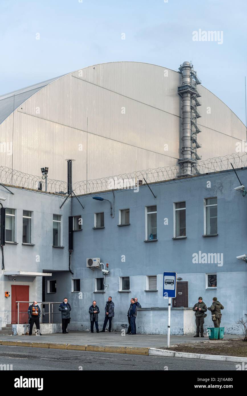 Personale in attesa dell'autobus di fronte al reattore numero 4 che esplose a Chernobyl. Zona di esclusione di Cernobyl. Foto Stock