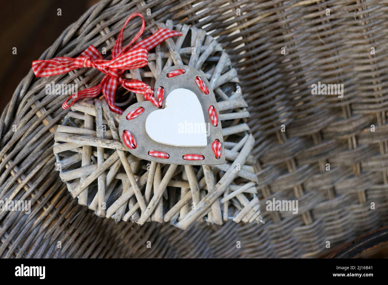 Cuore bianco con nastro rosso all'aperto. cuore in legno da appendere.  concetto di romanticismo e amore. san valentino