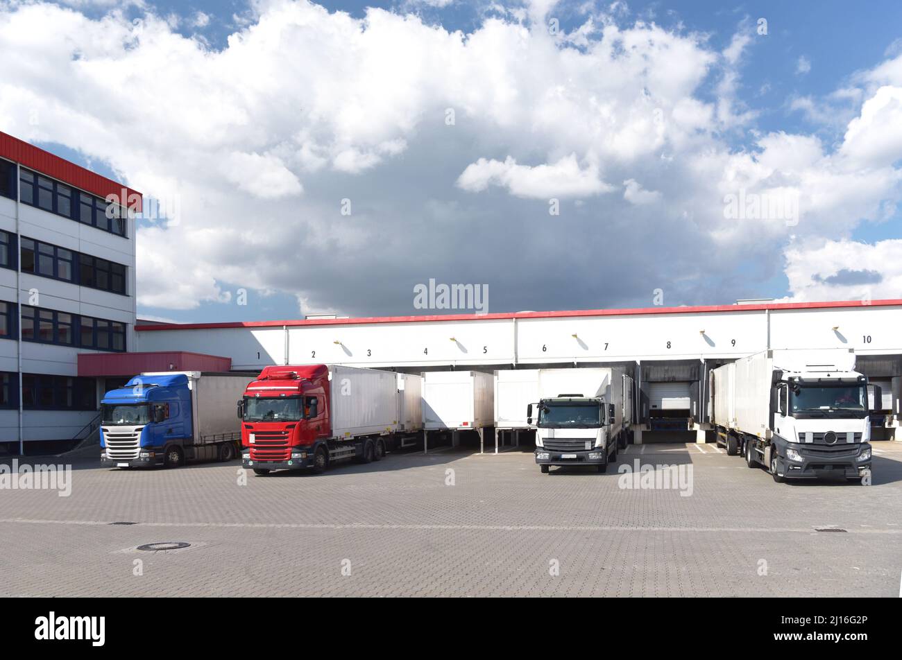 Camion che caricano ad un deposito di un'agenzia di spedizione - Trasporti e logistica nel commercio di merci Foto Stock
