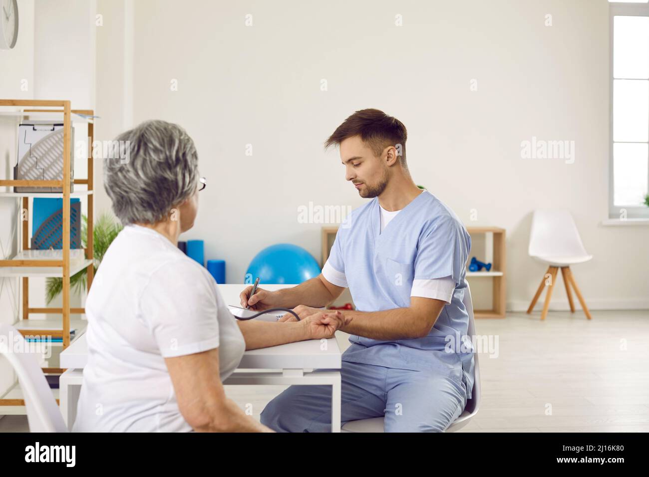 Donna anziana con ipertensione ottenendo la sua pressione sanguigna misurata in clinica o ospedale Foto Stock