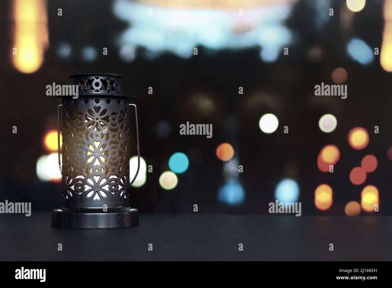Lanterna, lampada a candela con sfondo luminoso bokeh città. Musulmano, mese santo di Ramadan Kareem. Foto Stock
