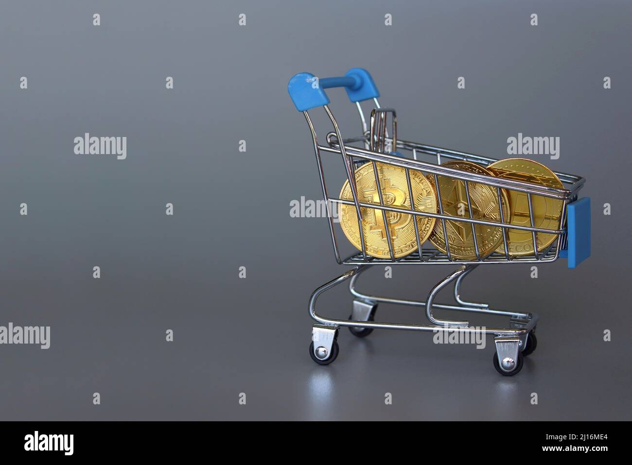 Carrello per lo shopping e criptovaluta. Bitcoin, Dogecoin ed Ethereum. Sfondo grigio. Spazio di copia Foto Stock