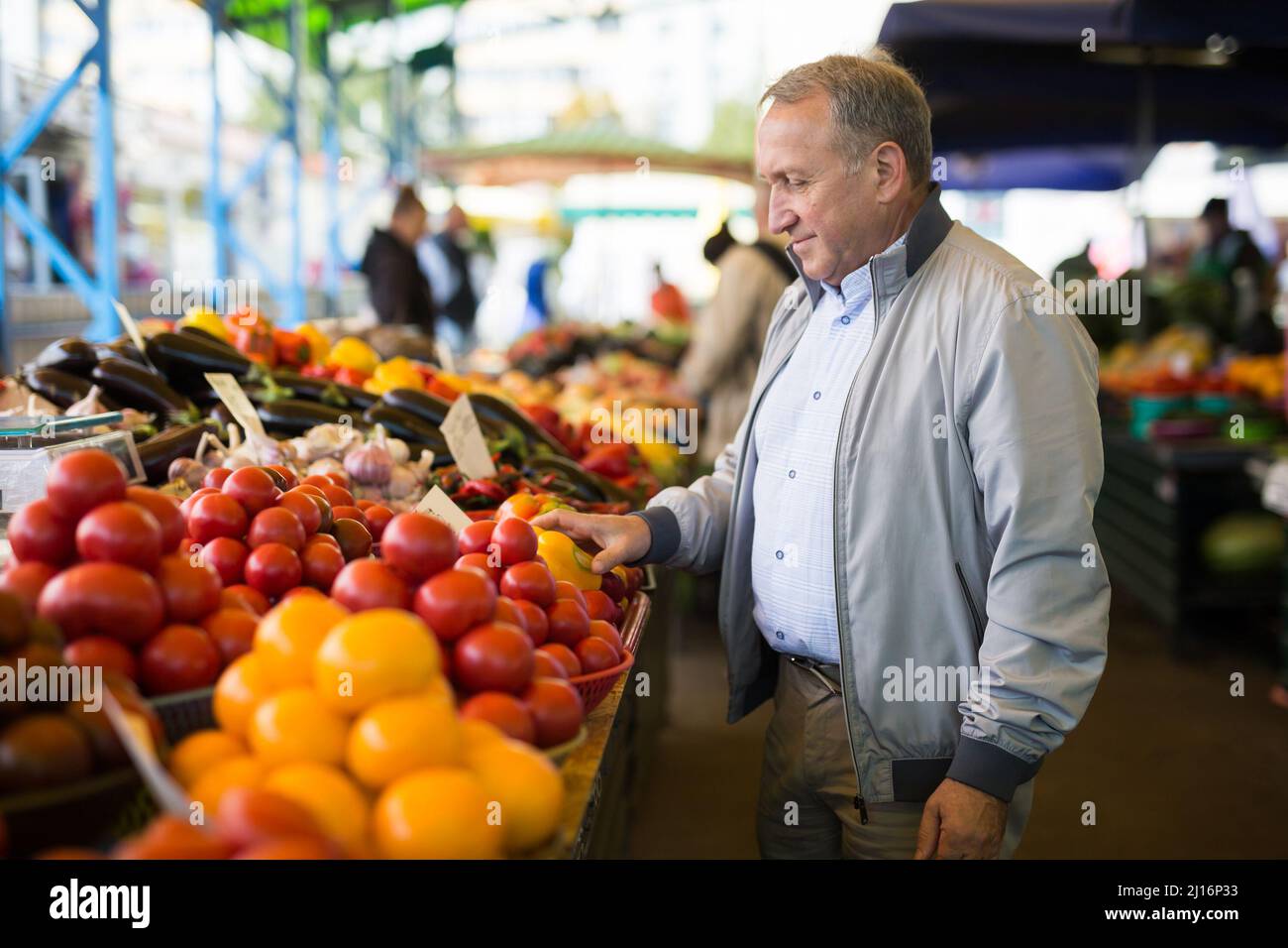 Uomo che acquista peperoni in gregrocery Foto Stock