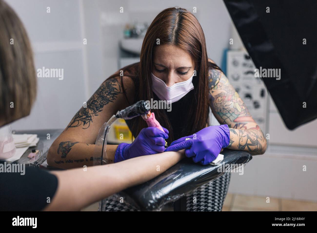 Tatuaggio femminile con maschera e guanti. Tatuaggio arte sul corpo. Foto Stock
