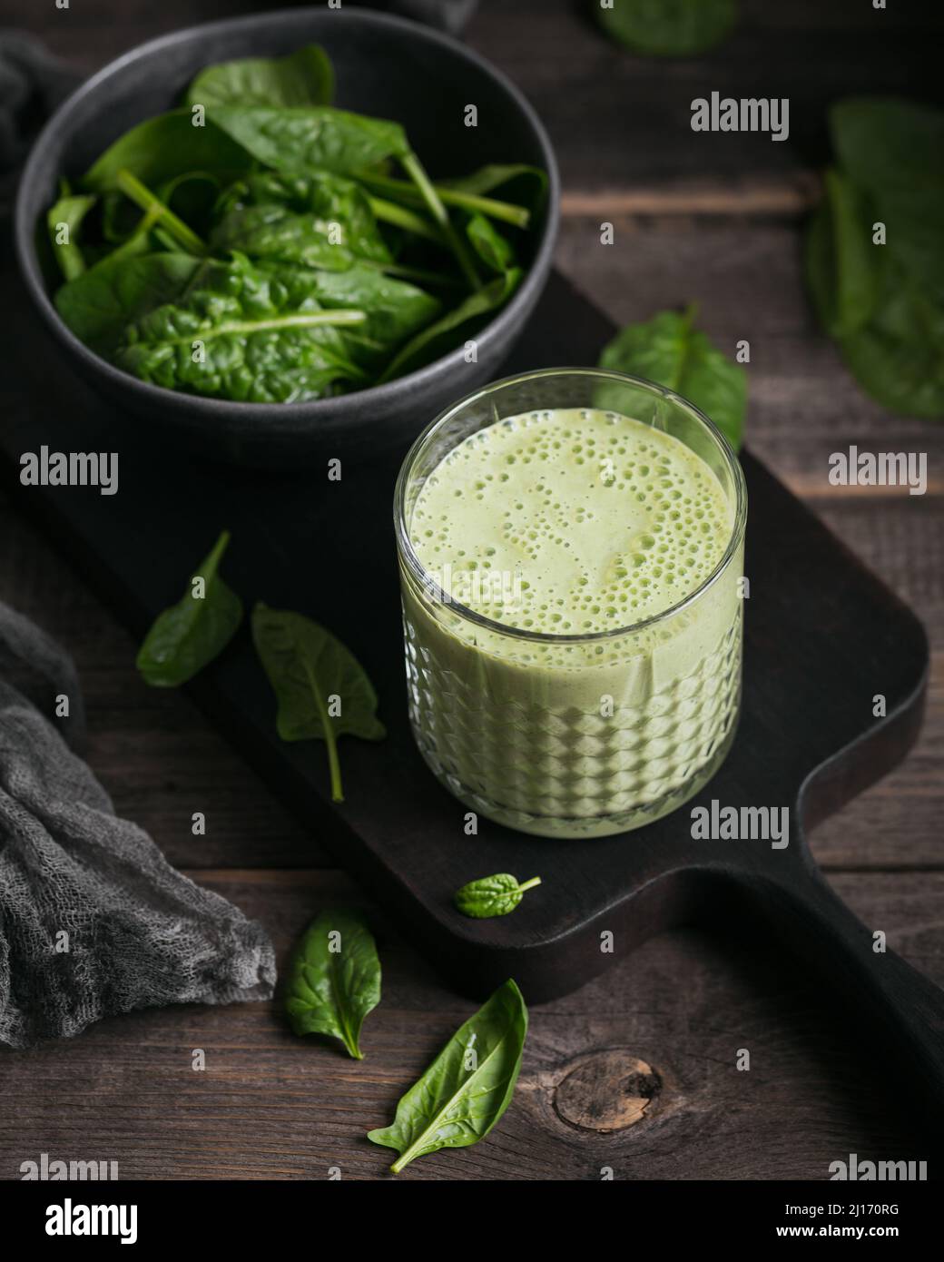 Bicchiere di frullato verde sano fatto in casa con spinaci freschi su sfondo scuro. Cibo e bevande, dieta e concetto di cibo sano Foto Stock